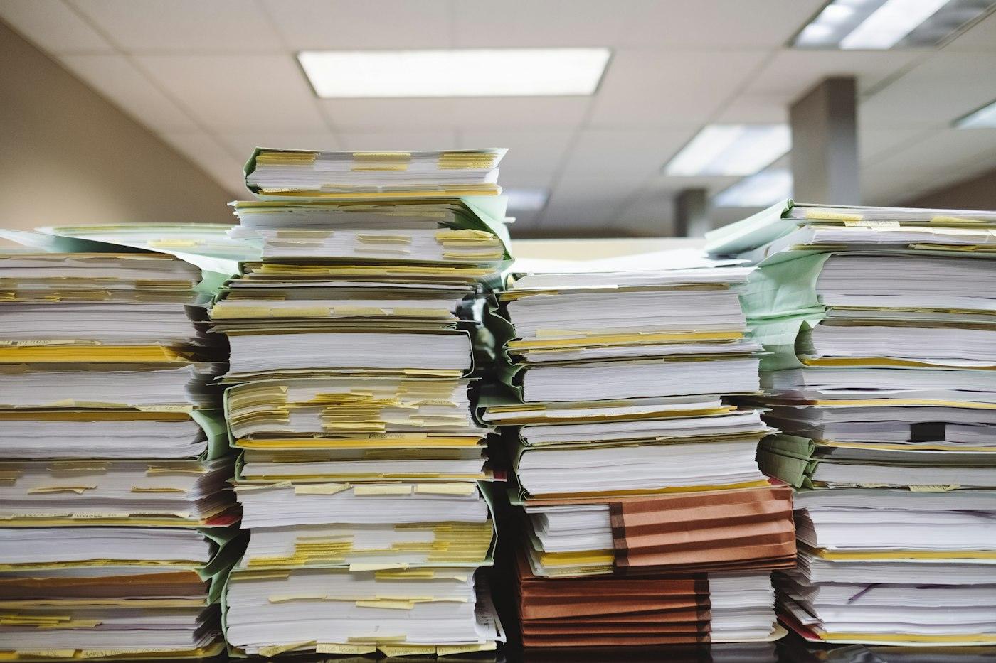Tall stacks of paper files and folders in an office
